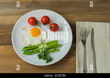 Grüner Spargel mit Spiegelei, Cherry-Tomaten für gesundes Frühstück. Stockfoto
