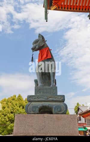 Statue von Kitsune mit einem Schlüssel im Fushimi Inari-Taisha Shinto-Schrein in Kyōto, Japan. Kitsune ist ein Fuchs Shapeshifter und ein Diener der Göttin Inari Stockfoto