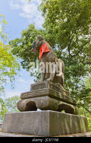 Statue von Kitsune mit einem Schlüssel im Fushimi Inari-Taisha Shinto-Schrein in Kyōto, Japan. Kitsune ist ein Fuchs Shapeshifter und ein Diener der Göttin Inari Stockfoto