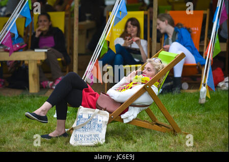 Frau auf Smartphone & anderen Besuchern Entspannung in Liegestühlen am Hay Festival für Literatur und Kunst 2017 Hay-on-Wye Powys Wales Großbritannien Stockfoto