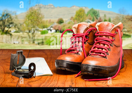 Wanderschuhe, Karte und Kompass mit Berg im Hintergrund Stockfoto