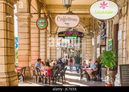 Cagliari Arcade, entspannen Sie Menschen in einer Café-Terrasse innerhalb einer Arkaden Straße in der Via Roma im Stadtteil Marina Cagliari, Sardinien. Stockfoto