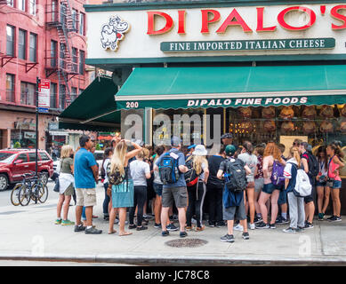 Eine Gruppe von jungen Touristen wird hielt einen Vortrag über das Essen von Little Italy vor DiPalo italienischen Deli auf Grand Street Stockfoto