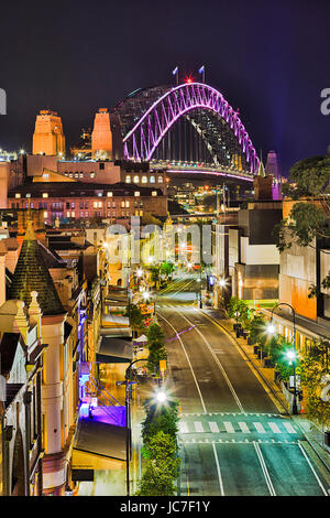 Historischen Vorort von Sydney City - The Rocks, gegen die Sydney Harbour Bridge bei Vivid Sydney-Licht-Show. Beleuchtete Bogen der Brücke dominiert ove Stockfoto