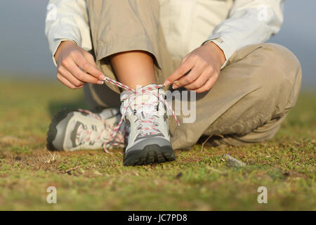 Wanderer-Frau binden Schnürsenkel Schuhe mit einem unscharfen Hintergrund Stockfoto