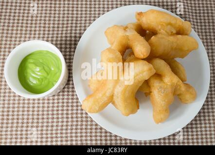 Snack und Dessert, chinesische traditionelle Snacks Deep Fried Doughstick auf einem weißen Teller mit Pandan Kokosnuss Creme Dip serviert. Stockfoto