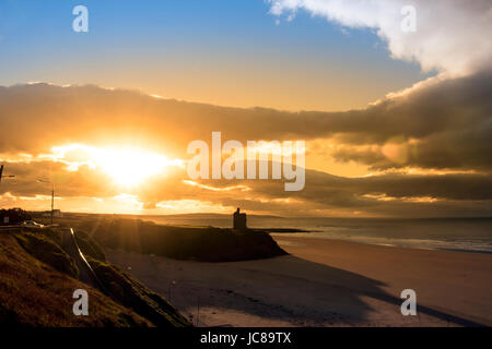 Schöne gelbe Sonne über den Ballybunion Strand und Schloss in Irland an einem Sommertag Stockfoto
