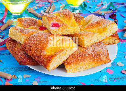 eine Platte mit Stücken von Coca de Sant Joan, eine typische süße Fladen aus Katalonien, Spanien, gegessen auf Saint Johns Eve, auf einem rustikalen blaue Tabelle mit Cham Stockfoto