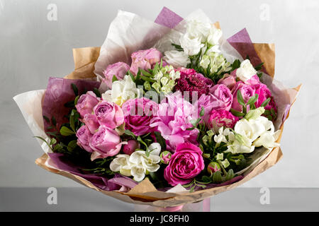 luxuriöses und elegantes Bukett von Rosen und anderen Blumen. Zusammensetzung der Farben auf grauem Hintergrund. Kopieren Sie Raum. Stockfoto