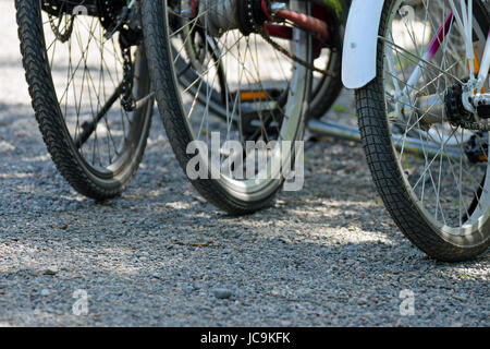 Drei Fahrräder außerhalb geparkt. Nahaufnahme der Hinterräder. Stockfoto