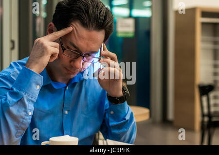 Nahaufnahme von depressiv und frustriert Geschäftsmann auf dem Handy. Schlechte Nachrichten. Besorgt junger Geschäftsmann in Anzug und Krawatte telefonieren mit dem Handy Stockfoto