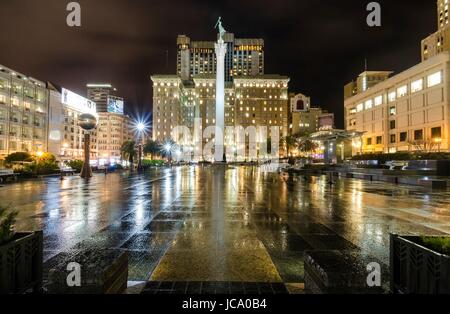 Eine Nacht-Blick auf den Union Square in der Innenstadt von San Francisco, California, Vereinigte Staaten von Amerika. Ein Wahrzeichen der Gegend mit einer Spalte mit einer Statue des Sieges hält einen Dreizack im Herzen des Stadtzentrums an der Spitze. Stockfoto