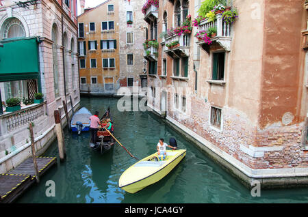 Boote bewegen in einem engen Kanal in Venedig, Italien. Venedig befindet sich in einer Gruppe von 117 kleine Inseln, die durch Kanäle getrennt und verbunden durch bri Stockfoto