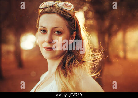 Junge, blonde Frau mit Sonnenbrille Porträt im Abendlicht Stockfoto