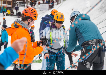 Eine Frau wird in ein Seil an einer Eisklettern-Klinik an der Wand die Kinder während der Ouray Ice Festival auf dem Eis-Park in Ouray, Colorado gebunden. Stockfoto