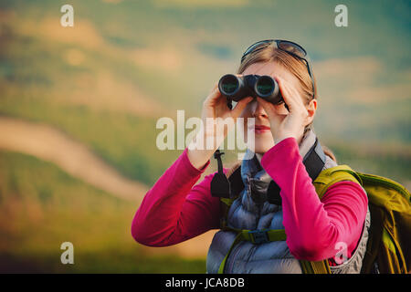 Junge Frau Tourist mit dem Fernglas suchen in den Bergen Stockfoto