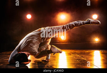 Junger Mann Breakdance im Club mit roten Lichtern. Lebendige kontrastreichen Farben. Stockfoto
