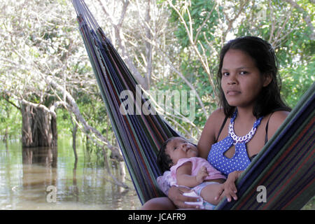 MANAUS, 10.06.2017: Junge Frau in der Hängematte, mit ihrem Baby in einem der wenigen Inseln auf Amazonas im brasilianischen Amazonas Regenwald. (Foto: Nésto Stockfoto