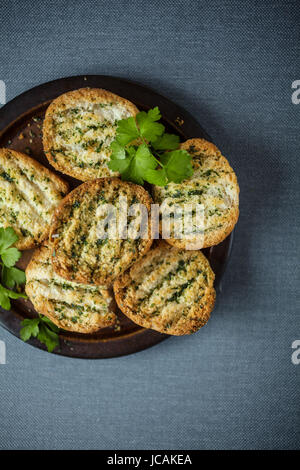 Leckere knuspriges golden gegrilltes oder geröstetes Brot gewürzt mit frischen Kräutern für einen herzhaften Begleitung oder Vorspeise zu einem Abendessen Stockfoto