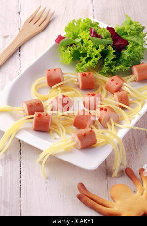 Wiener und Nudel-Spider-Snacks auf weißen Teller mit garnieren Schuss von oben Stockfoto