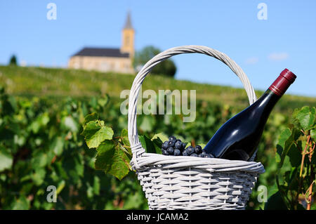 Flasche Rotwein in einem Korb aus Gründen in der Nähe eine typische Kirche Stockfoto