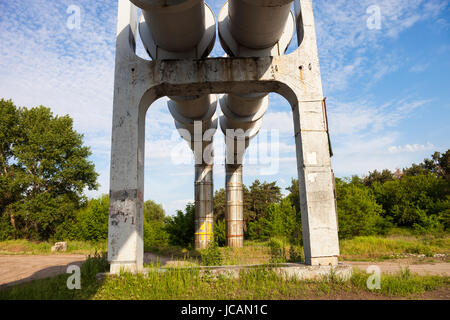 Erhöhten Bereich der Rohrleitungen mit der konkreten Unterstützung gegen den Himmel Stockfoto