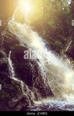 Schöner Wasserfall in den wilden Wald. Sonnenuntergang. Stockfoto