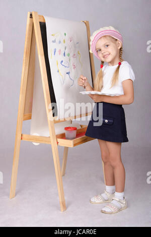 Vier-jährigen Mädchen spielen in der Künstler und stützt sich auf die Tafelmalerei. In den Armen der Kinder Pinsel und Palette. Stockfoto