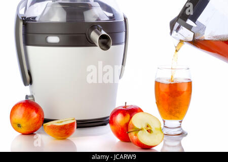 Entsafter und Apfelsaft vorbereiten gesunden frischen Saft auf weißem Hintergrund Stockfoto