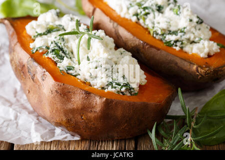 Pflegende Essen: gefüllte Süßkartoffel mit Käse und Spinat Nahaufnahme auf dem Tisch. horizontale Stockfoto