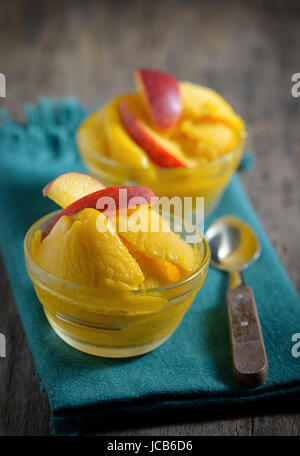 Hausgemachte Mango-Eis-Sorbet mit Pfirsich Scheiben Stockfoto