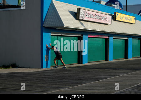 Läufer erstreckt sich gegen bunte Gebäude auf dem Rehoboth Strand, DE Promenade... Stockfoto