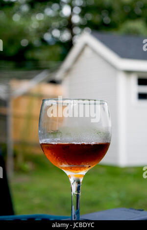 Nahaufnahme der bernsteinfarbene Flüssigkeit im Glas Wein Schwitzen Stockfoto