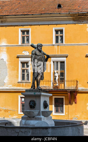 Herkules-Statue vorne mit weiblichen Statue am Balkon im unscharfen Hintergrund in Baile Herculane berühmt für seine natürlichen heilenden Eigenschaften: heiße Quellen mit Schwefel und anderen Mineralien. Stockfoto