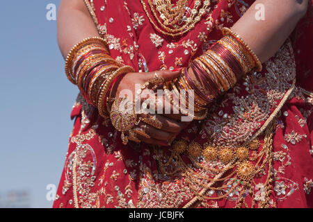 Eine indische Braut mit Schmuck Armreifen geschmückt und mit Henna bemalt. Stockfoto