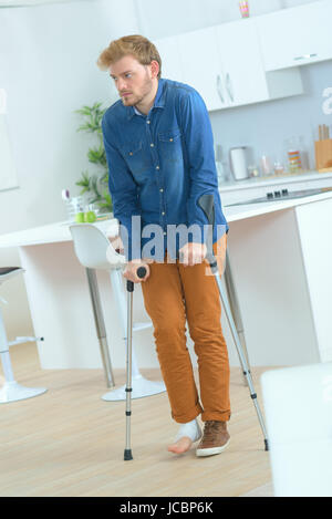 Mann mit Krücken Rehabilitation nach Verletzungen Stockfoto