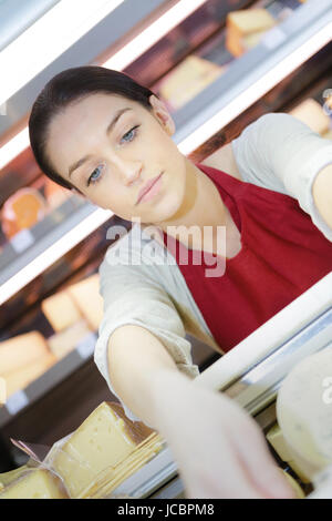 glückliche Frau verkaufen verschiedene Käsesorten Stockfoto