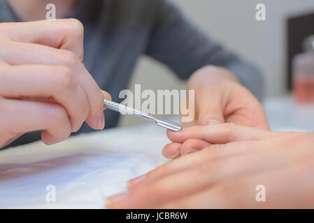 Nahaufnahme von professionelle Maniküre mit Nagelhautschieber tun Maniküre Stockfoto