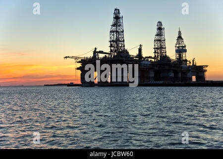 Deepwater Dril Bohrinseln bei Sonnenuntergang, vorübergehend in Lagerung, Harbor Island, Canyon Port, Port Aransas auf der rechten Seite. Stockfoto