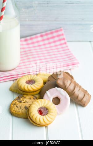 Verschiedene Kekse und Milch am Küchentisch. Stockfoto