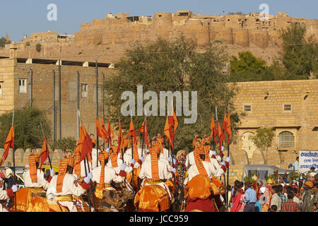 Kamele und Fahrer der Border Security Force führt eine Prozession durch die Altstadt während des Wüste Festivals in Jaisalmer, Rajasthan, Indien. Stockfoto