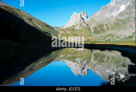 Kalkstein-Pyramiden spiegelt sich auf Combal Seewasser in Val Veny, Italien Stockfoto