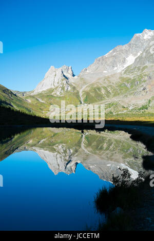 Kalkstein-Pyramiden spiegelt sich auf Combal Seewasser in Val Veny, Italien Stockfoto