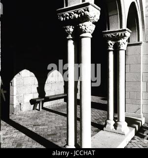 Mittelalterliche Kolonnade aus dem 12. Jahrhundert BCE. Am späten Nachmittag mit langen Schatten.  Schwarz / weiß Foto. Kreuzgang einer mittelalterlichen Kirche. Stockfoto