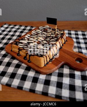 Toast belegt mit in Scheiben geschnittenen Bananen, Nüssen, Schokolade und Karamell-Sirup Stockfoto