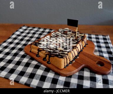 Toast belegt mit in Scheiben geschnittenen Bananen, Nüssen, Schokolade und Karamell-Sirup Stockfoto