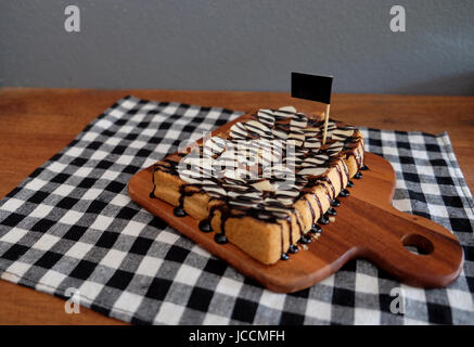 Toast belegt mit in Scheiben geschnittenen Bananen, Nüssen, Schokolade und Karamell-Sirup Stockfoto