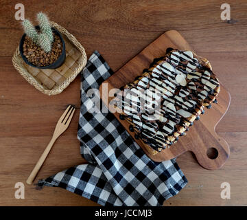 Toast belegt mit in Scheiben geschnittenen Bananen, Nüssen, Schokolade und Karamell-Sirup Stockfoto