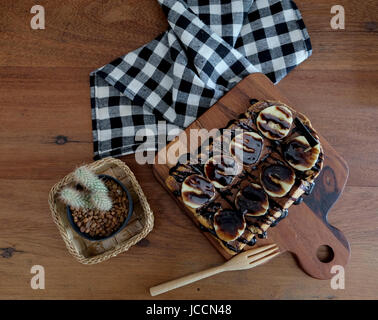 Toast belegt mit in Scheiben geschnittenen Bananen, Nüssen, Schokolade und Karamell-Sirup Stockfoto