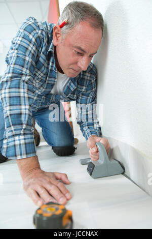 Fliesenleger markiert die Kachel während der Verlegung Stockfoto